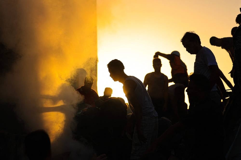 Palestinians search through the rubble of a collapsed building searching for survivors and victims following the Israeli bombardment of Khan Yunis in the southern Gaza Strip on Nov 4 - Photo by Mahmud Hams / AFP