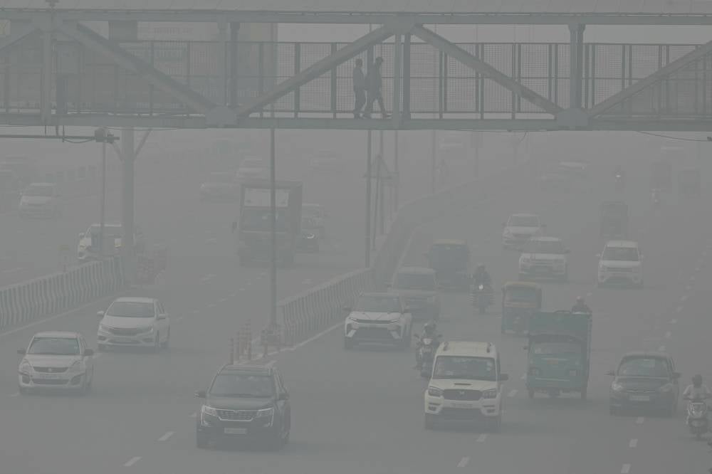 Commuters make their way along a road amid heavy smoggy conditions in New Delhi on Nov 5 - Photo by Arun Sankar / AFP