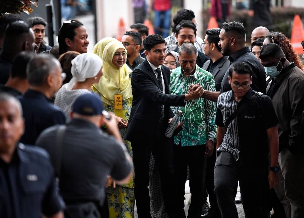 Muar MP Syed Saddiq Syed Abdul Rahman accompanied by his mother Shariffah Mahani Syed Abdul Aziz and father Syed Abdul Rahman Abdullah Asagoff at the Kuala Lumpur Courts Complex, today. - Photo by Bernama