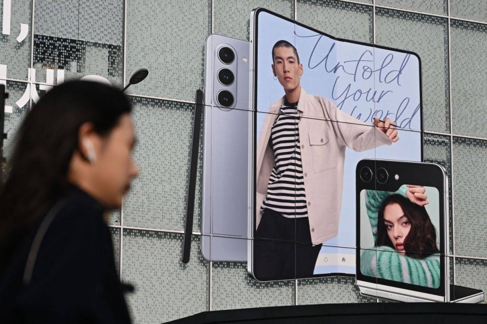 A woman walks past an advertisement for the Samsung Galaxy Z Fold5 and Z Flip5 smartphones at a Samsung Electronics store in Seoul on October 31, 2023. South Korea's Samsung Electronics said on October 31 that its operating profits for the July to September period were down 77.57 percent from the year before, even as new smartphone releases boosted revenue. - Photo by Jung Yeon-je AFP
