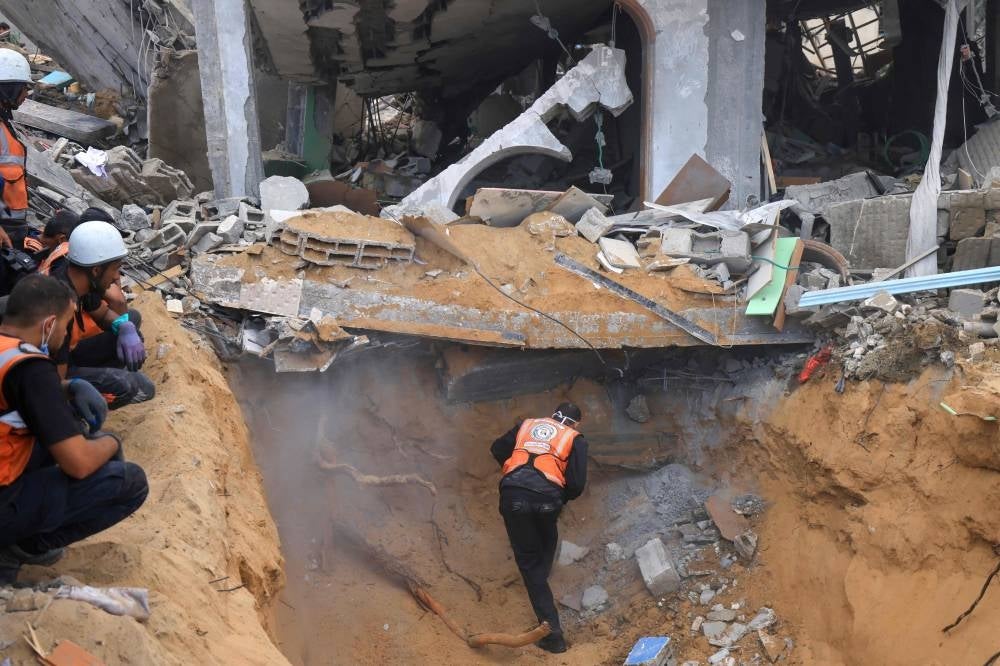 Rescuers look for survivors amid the rubble of a destroyed building following an Israeli bombardment in Khan Yunis in the southern Gaza Strip on Nov 12, 2023. (Photo by Mahmud HAMS / AFP)