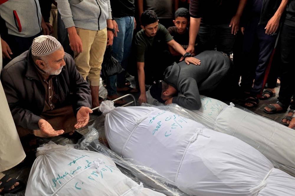 Relatives mourn over the bodies of loved ones killed during overnight strikes on Rafah in the southern Gaza Strip, at Al-Najjar hospital on Nov 12, 2023, amid the ongoing bombing by Israel. (Photo by SAID KHATIB / AFP)