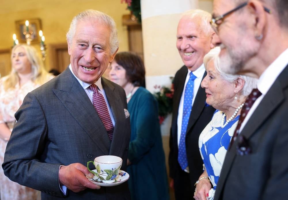 Britain's King Charles III reacts whilst holding a cup and saucer, as he meets with guests during a 75th birthday party for him, hosted by the Prince's Foundation, at Highgrove House in Tetbury, western England on Nov 13, 2023. (Photo by Chris Jackson / POOL / AFP)
