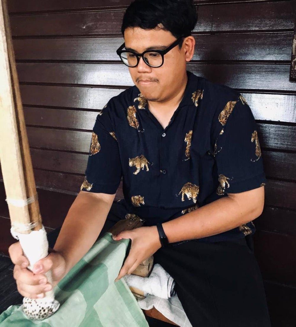 Textile cultural researcher and advocate Khairulanwar Rahmat demonstrating a calendering (or burnishing) technique known as 'menggerus kain’ - PIX by Khairulanwar Rahmat