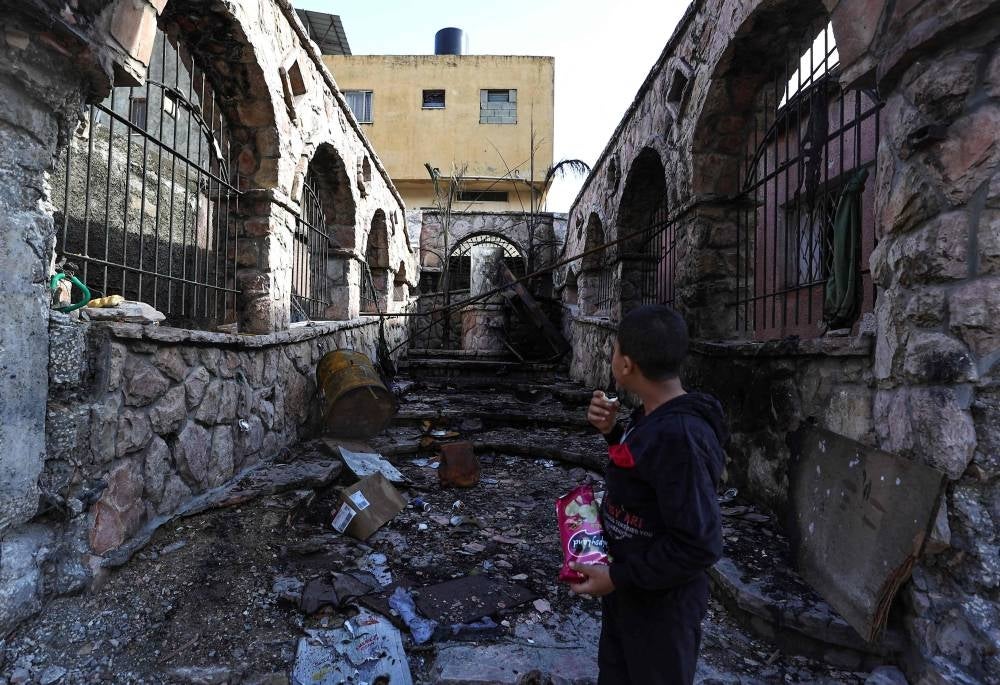 A Palestinian boy checks a damaged street in the aftermath of an Israeli raid at the Balata refugee camp in the West Bank on November 21, 2023, as violence has escalated in the occupied Palestinian territory amid Israel's war against Hamas in Gaza - AFP