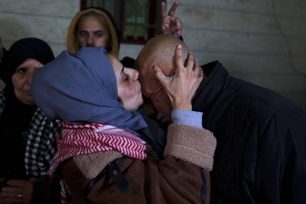 Newly freed Palestinian prisoner Lamees Abu Arqub kisses her father following the release of prisoners from Israeli jails in exchange for Israeli hostages held in Gaza by Hamas. Photo by Hazem Bader/AFP