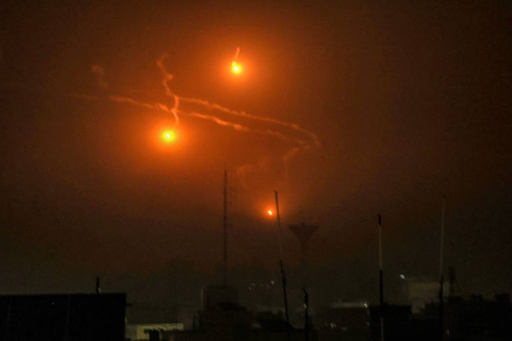 A picture taken from Rafah, on the southern Gaza Srip, shows flares dropped during Israeli bombardment - AFP 