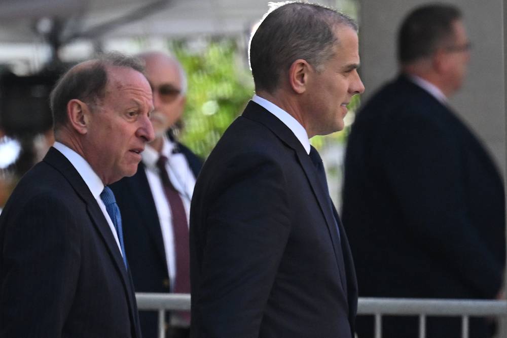 Hunter Biden (C) was indicted late Thursday on multiple counts of tax evasion, the second time this year President Joe Biden's troubled son has been charged by a special counsel investigating his personal and business dealings. - AFP