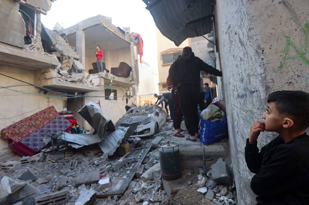 A young boy looks on as Palestinians check the damage following Israeli bombardment on Khan Yunis in the southern Gaza Strip on December 8, 2023 - AFP 