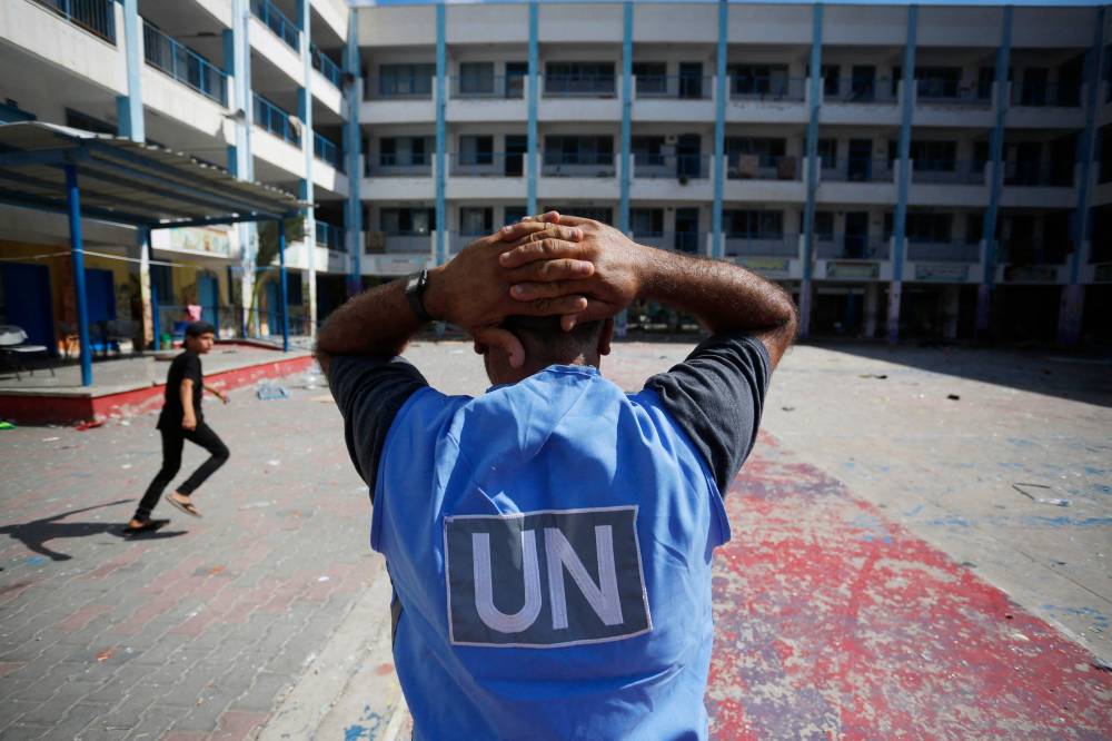 A United Nations' volunteer stands in the yard of a UN-run school in the refugee camp of Al-Maghazi in the central Gaza Strip, a day after at least 6 people were killed in a reported Israeli strike, on October 18, 2023 - AFP 