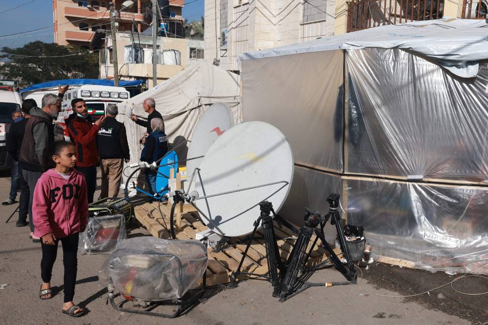 Journalists stand outside makeshift shelters in Rafah on the southern Gaza Strip on December 11, 2023, amid continuing battles between Israel and Hamas. (Photo by MOHAMMED ABED / AFP)