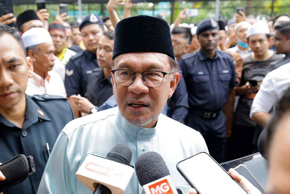 Prime Minister Datuk Seri Anwar Ibrahim talking to reporters after Friday prayers - BERNAMA