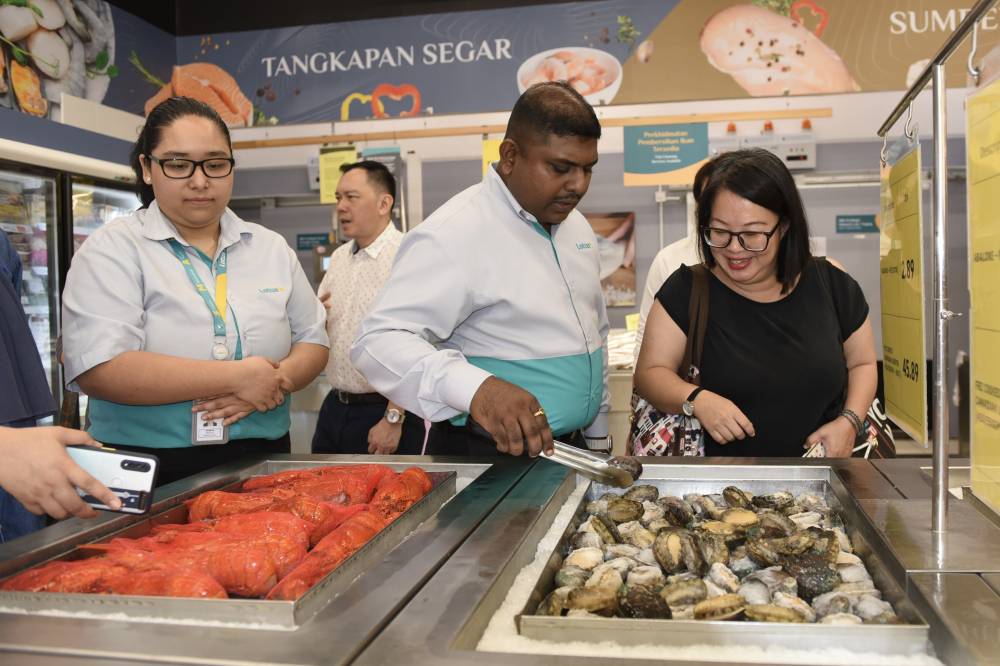 Lotus's Malaysia Central 1 Region Store director S.Thinesh (middle) and Lotus's Wangsa Walk store manager Amanda Joseph (left) at the seafood section at Lotus's Wangsa Walk in Wangsa Maju, today. - Photo by MOHD RAFIQ REDZUAN HAMZAH