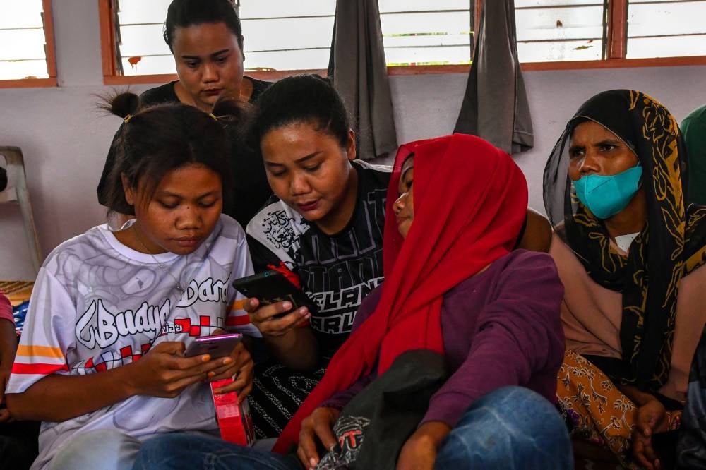 Orang Asli women from the Mendriq tribe jotting down the words and sentences they use when met by Bernama in Kampung Lah recently. - Photo by Bernama