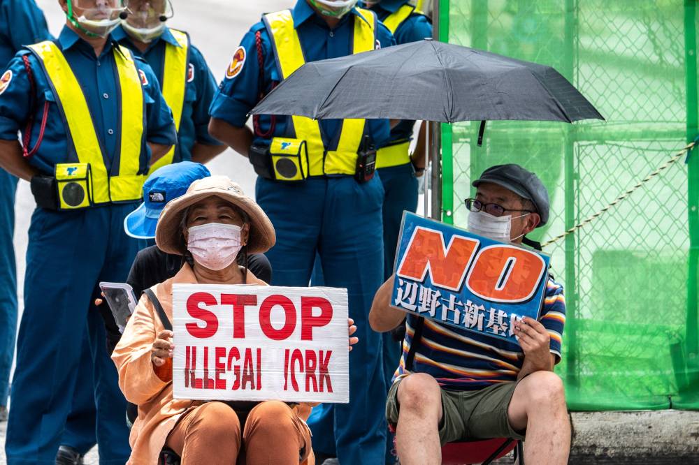 This picture taken on August 24, 2022 shows anti-base activist Suzuyo Takazato (bottom L) taking part in a protest outside Henoko US base in Nago, Okinawa Prefecture. (Photo by Philip FONG / AFP)