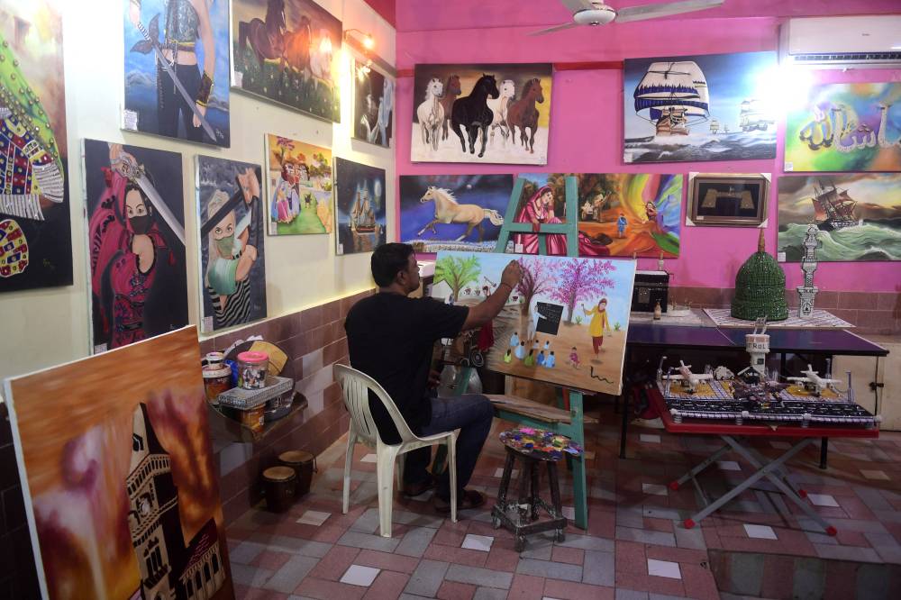 Mohammad Ijaz, an artist and a former convict, paints a canvas at the central jail in Karachi on Dec 16, 2023. Mohammad recently sold his artwork for 1.3 million rupees at the Art and Craft Exhibition organised by prison authorities. The central jail in Karachi provides facilities for prisoners to enhance their skills in paintings, fine arts, and handicraft. - (Photo by ASIF HASSAN / AFP)