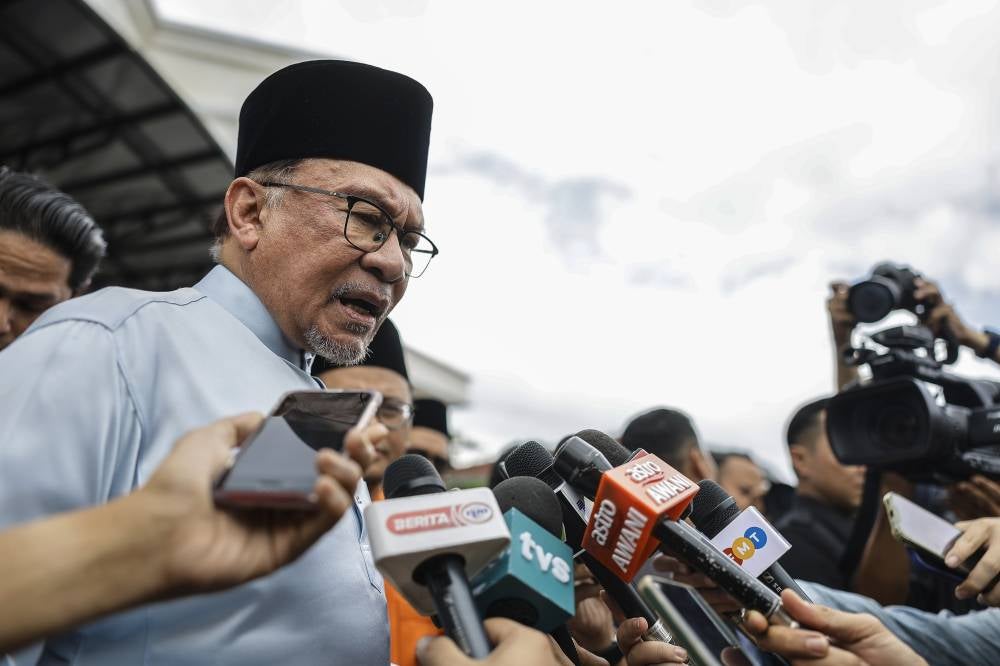 Anwar speaking to reporters after performing Friday prayers at the Kota Damansara Mosque today. Photo by Bernama