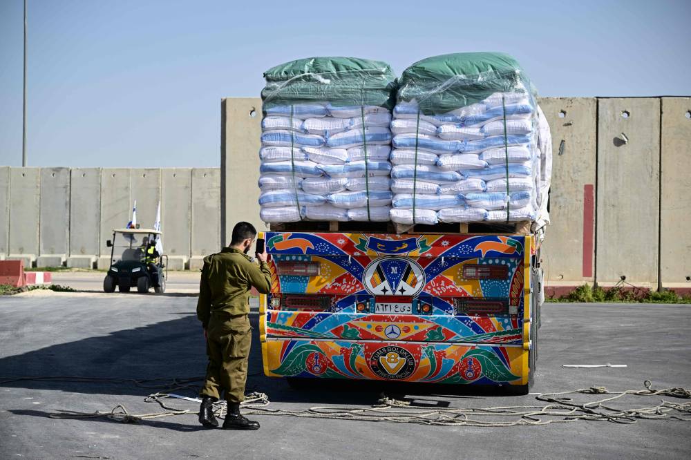 A member of Israeli security forces inspects humanitarian aid trucks arriving from Egypt on the Israeli side of the Kerem Shalom border crossing with the southern Gaza Strip. Photo by Alberto Pizzoli/AFP