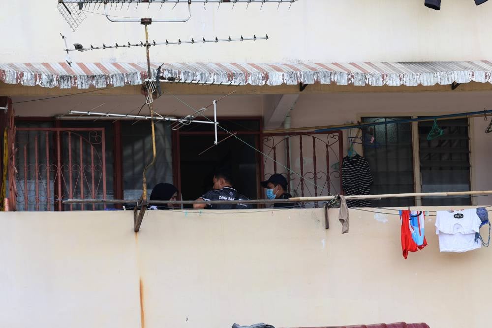 A police forensics team gathering materials from the victim's home on Dec 25. - Photo by Bernama