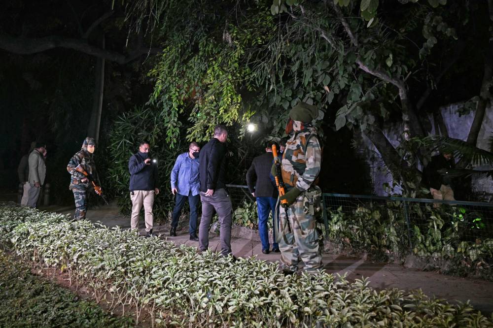 Officials along with police personnel conduct a search operation after an alleged explosion occured near the embassy in New Delhi on December 26, 2023. - Photo by AFP