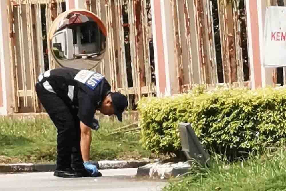 Policemen checking the Kuala Terengganu Court Complex's compound following the discovery of a suspicious package.