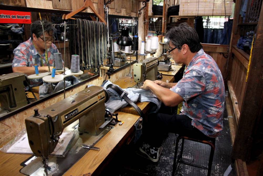 Shukri altering jeans at his shop in Jalan Sultan Idris Shah. Photo by Bernama