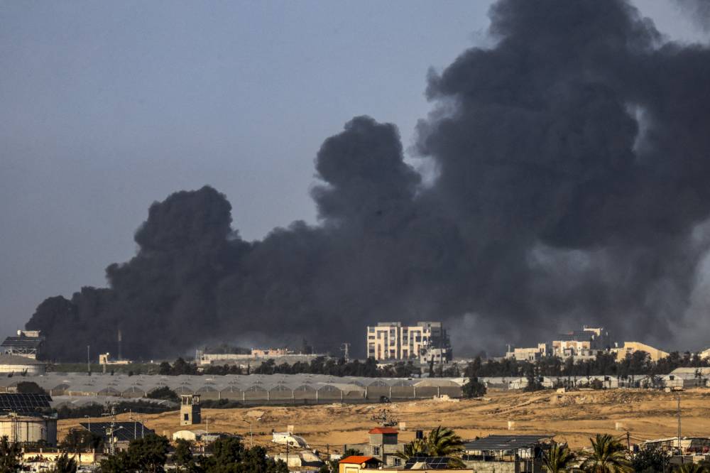 A picture taken from Rafah shows smoke billowing over Khan Yunis in the southern Gaza Strip during Israeli bombardment on Jan 22, 2024. - Photo by AFP