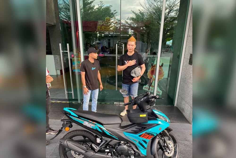 Faisal (left) handed over a motorcycle to Derrick in Bukit Jalil, Kuala Lumpur on Sunday. Photo Agency