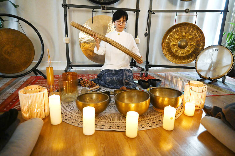 Li Yan makes sounds with a rain stick during a one-hour sound healing session at the Yiyan sound healing studio in Beijing. Photo by AFP