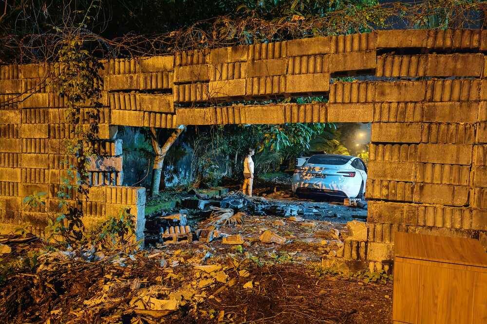 One of the pictures shared by YC Shaun's Facebook account showing a Tesla crashes through a wall in the middle of the road.