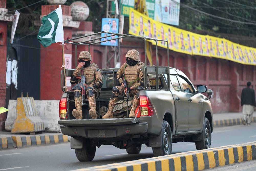 Military troops patrol near a polling station during Pakistan's national elections in Lahore on Feb 8, 2024. - (Photo by AAMIR QURESHI / AFP)
