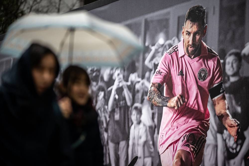 Pedestrians walk past an advertisement of Inter Miami's Argentine forward Lionel Messi at a shopping street in Shibuya district of Tokyo on February 5, 2024, ahead of the friendly football match between Inter Miami and Vissel Kobe on February 7. - Photo by AFP