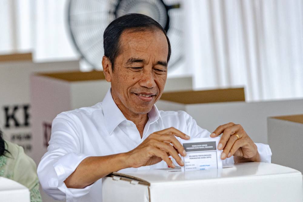 Indonesian President Joko Widodo casts his ballot during the presidential and legislative elections at a polling station at the State Administration Agency in Jakarta on Feb 14, 2024. - (Photo by Mas Agung Wilis / AFP)