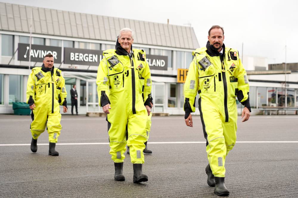 Crown Prince Haakon of Norway (R) and Norway's Prime Minister Jonas Gahr Store (C) prepare to fly out to open the Hywind Tampen floating offshore wind farm, situated between energy company Equinor's oil and gas fields Snorre and Gullfaks in the Norwegian North Sea off the coast of Bergen on August 23, 2023. (Photo by Ole Berg-Rusten / NTB / AFP) / Norway OUT