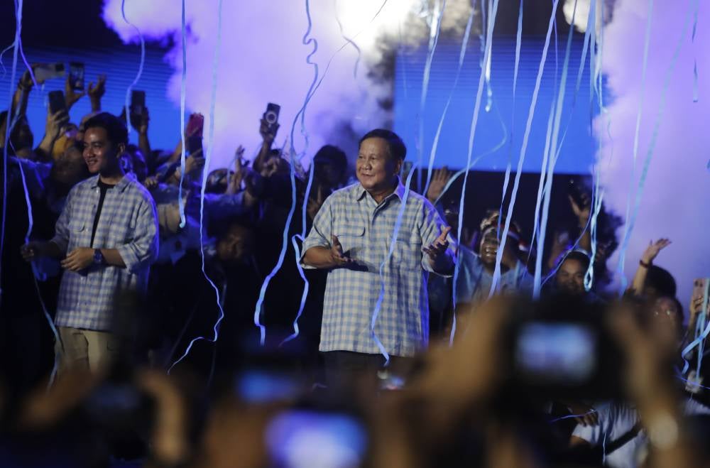 Indonesian Defence Minister and Presidential candidate Prabowo Subianto (C) and running mate Vice Presidential candidate Gibran Rakabuming Raka (L) celebrate amid a shower of confetti as they claim victory in the presidential elections at Istora Stadium, Jakarta, Indonesia Feb 14, 2024. (Photo by EPA/ADI WEDA)