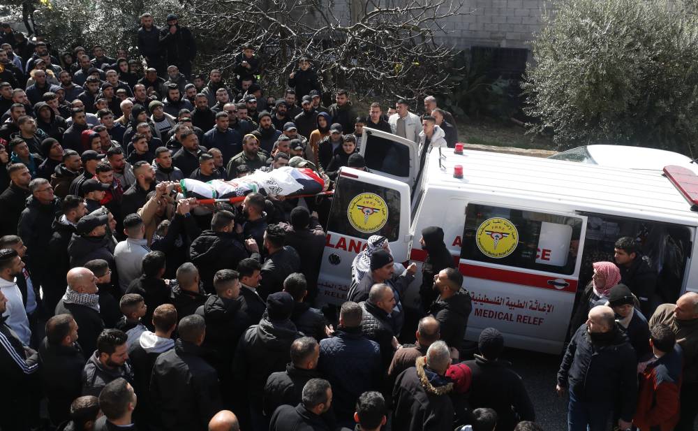 Mourners carry the body of Palestinian security officer Anas Dweikat, 26, during his funeral in the West Bank village of Rujeib, near the West Bank city of Nablus, Feb 19, 2024. (Photo by EPA/ALAA BADARNEH)