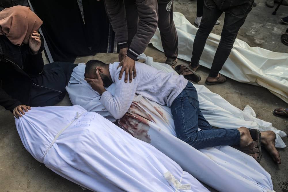 Relatives of a Palestinian family mourn over their covered bodies following Israeli air strikes in the town of Deir al-Balah, central Gaza Strip, 21 February 2024. Photo by Mohammed Saber/EPA