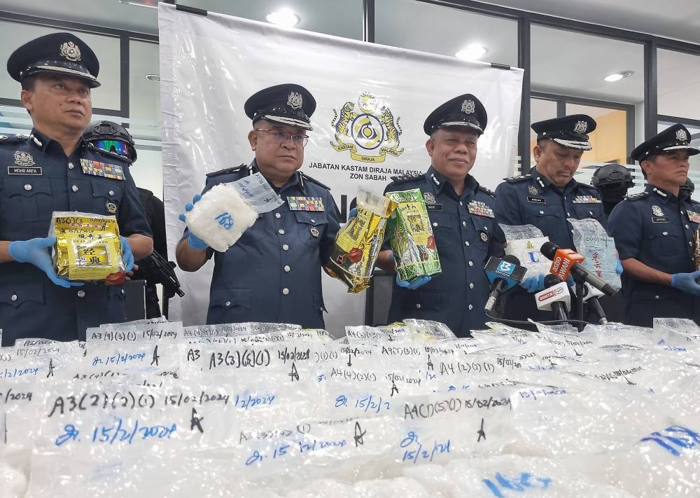 Sabah Zone Customs Assistant Director-General Datuk Mohd Nasir Deraman (three, left) showing the drugs weighing 205kg totaling RM6.85 million during a press conference today. - Photo by Bernama