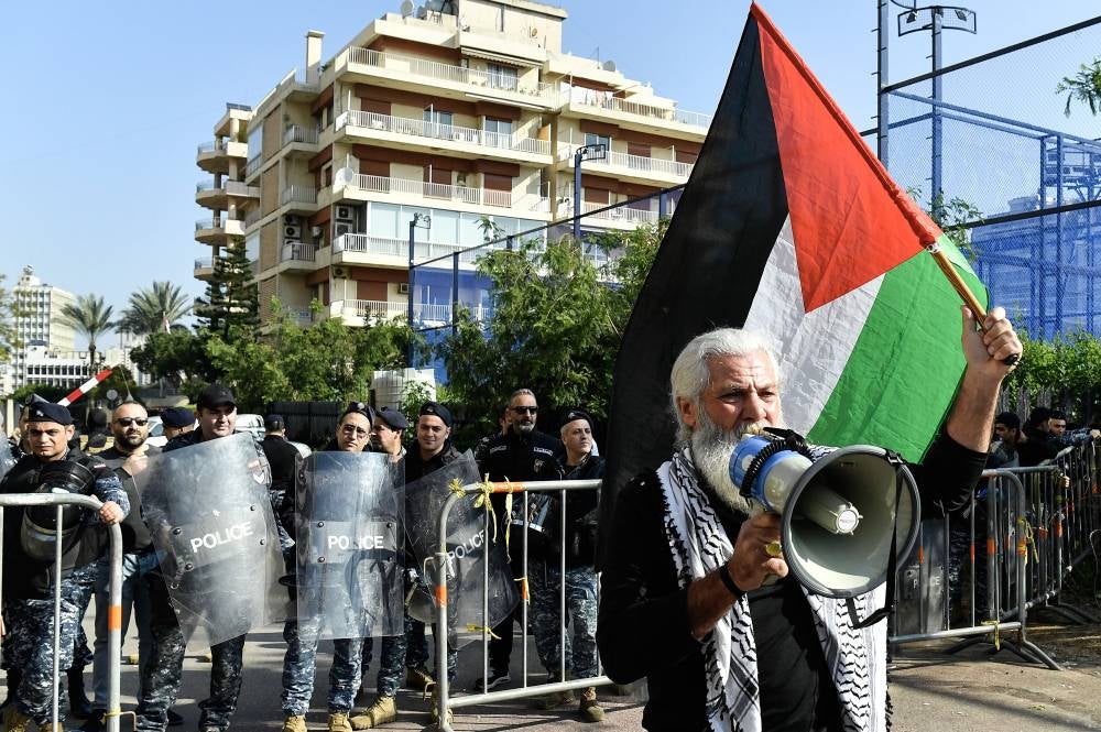 An activist holds a Palestinian flag as he shouts slogans during a protest to demand the opening of Rafah border crossing between Egypt and the Gaza Strip, outside of the Egyptian embassy in Beirut, Lebanon on Feb 22, 2024. (Photo by EPA/WAEL HAMZEH)