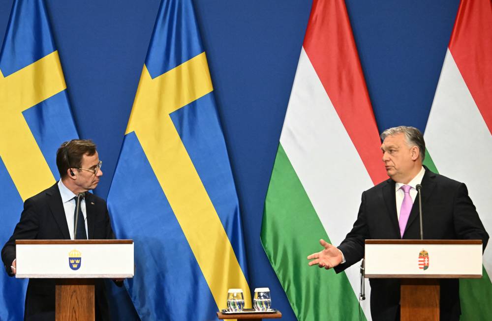 Swedish Prime Minister Ulf Kristersson (L) and his Hungarian counterpart and host Viktor Orban deliver a joint press conference in the Hungarian Prime Minister's office of Carmelita monastery in Budapest, Hungary, on Feb 23, 2024. - (Photo by ATTILA KISBENEDEK / AFP)