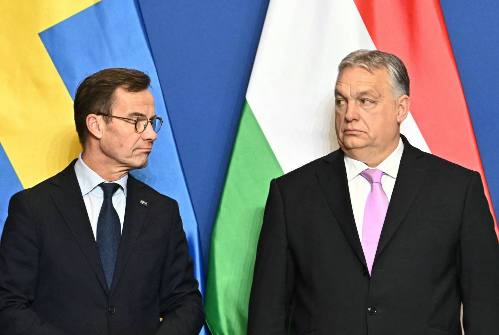Swedish Prime Minister Ulf Kristersson (L) and his Hungarian counterpart and host Viktor Orban pose prior a joint press conference in the Prime Minister's office of Carmelita monastery in Budapest, Hungary, on Feb 23, 2024. - (Photo by ATTILA KISBENEDEK / AFP)