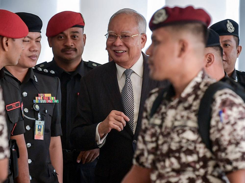 Former prime minister Datuk Seri Najib Razak (middle) at the Kuala Lumpur High Court for his 1MDB trial, today. - Photo by Bernama