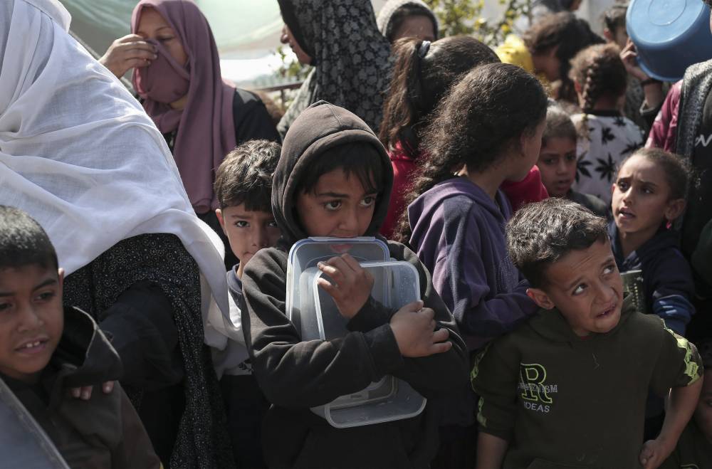 Displaced Palestinians gather for food in Rafah, on the southern Gaza Strip on Feb 28, 2024. - Photo by AFP