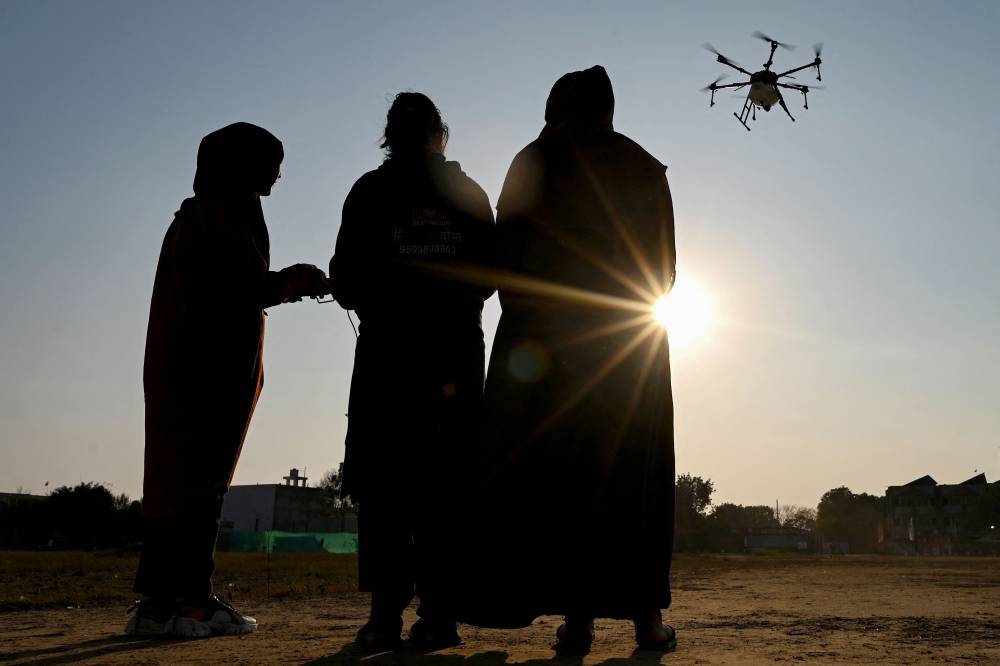 This photograph taken on February 28, 2024 shows Nisha Bharti (C), instructor at Drone Destination, training women aspiring to be remote pilots to operate a drone under the government-backed "Drone Sister" programme in Manesar. Hundreds of women have been trained in rural India to fly fertiliser-spraying aircraft under the government-backed "Drone Sister" programme. The scheme aims to help modernise Indian farming by reducing labour costs, as well as saving time and water in an industry hamstrung by its reliance on outdated technology and growing climate change challenges.
It is also a portent of rural India's changing attitudes towards working women, who have traditionally found few opportunities to join the labour force and are often stigmatised for doing so. (Photo by Sajjad HUSSAIN / AFP) 