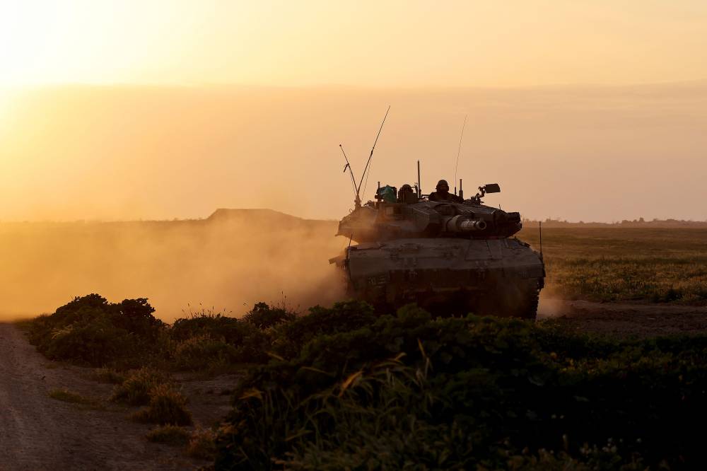A picture taken from Israel near the border with the Gaza Strip on March 6, 2024 shows an Israeli army tank moving along the border area, as battles between Israel and the Palestinian militant group Hamas continue. (Photo by AFP)