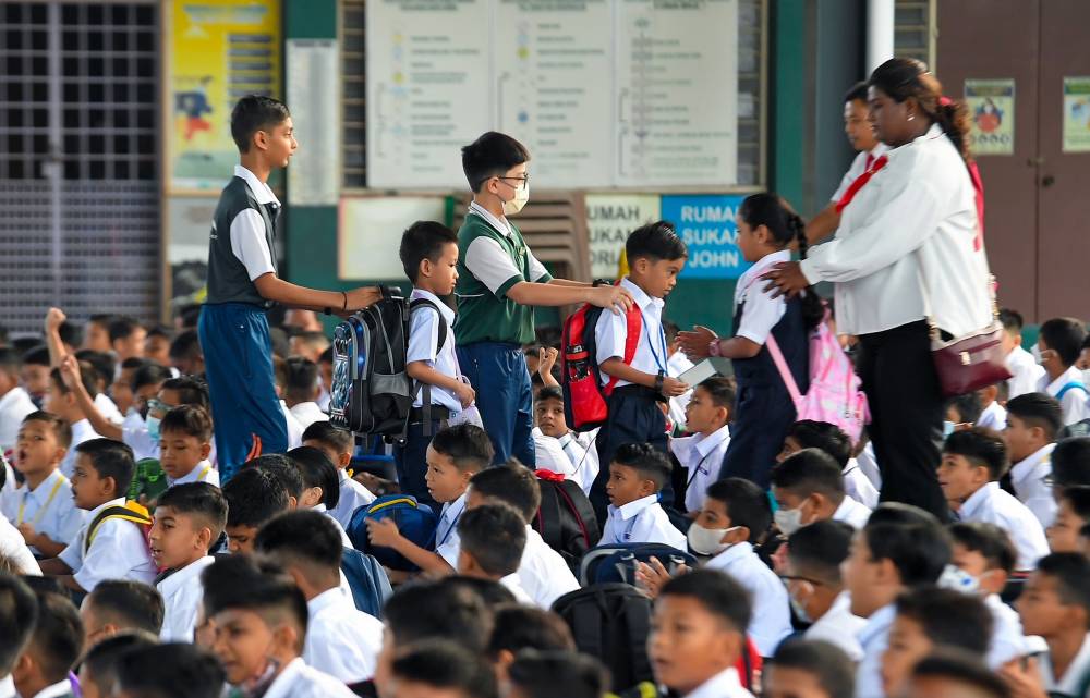 Teachers and prefects of Sekolah Kebangsaan (SK) St Paul Seremban helping the Year One pupils for the new school session today. - Photo by Bernama