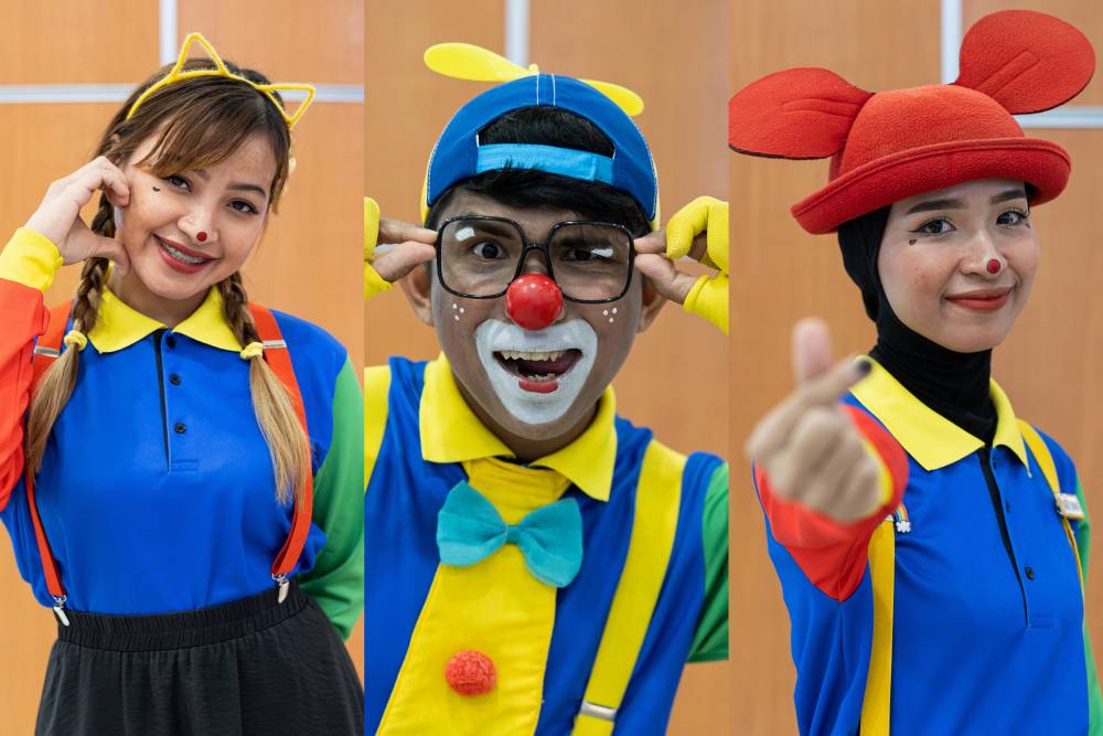 The journey of Muhammad Al-Hazim Ahmad, 32, his wife, Nor Farah Hanim Samsol Bahrin, 30, and her sister, Nor Aina Natasya Samsol Bahrin, 27 goes beyond just donning clown costumes; they've honed magic tricks and delved into the art of embodying clown characters. - Photo by Bernama