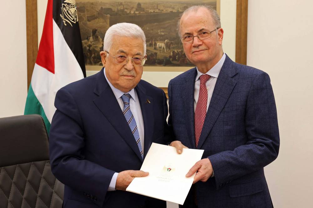 This handout picture provided by the Palestinian Authority's Press Office (PPO) shows Palestinian President Mahmud Abbas (L) posing with the newly appointed Palestinian Prime Minister Mohammad Mustafa, in Ramallah on March 14, 2024. - (Photo by PPO / AFP)