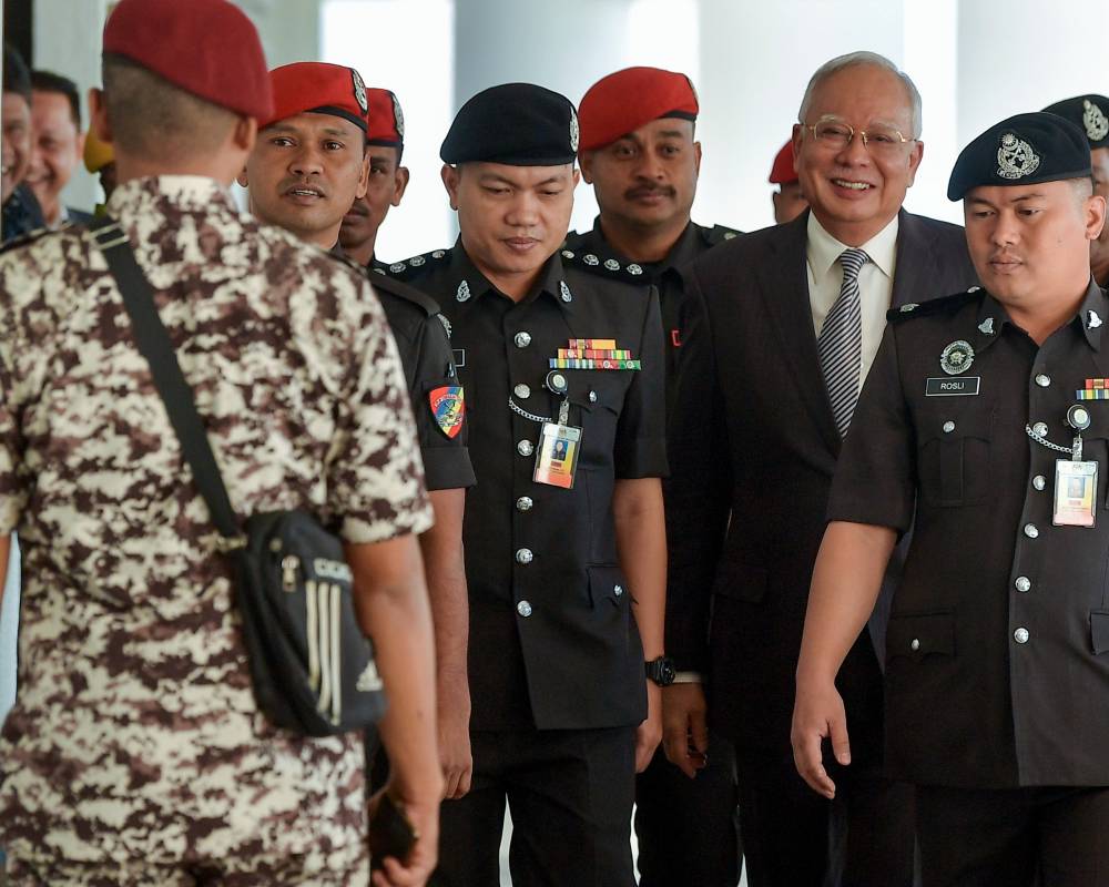 Former Prime Minister Datuk Seri Najib Razak (second, left) arrives at the High Court today.