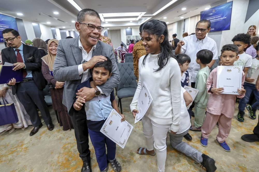 Saifuddin with children who received citizenship documents at Home Ministry. Photo by Bernama.